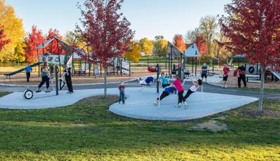One part fitness. One part playground.  All fun. While adults use the exercise equipment, children in the background play on the custom PlayBooster play system at Barb King Inspiration Park. A custom  one-of-a-kind park built in honor of Play LSI cofounder Barbara King.