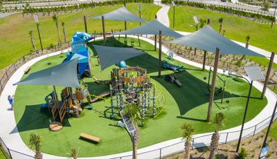 Elevated view of large shade sails covering a playground with a large custom bluebird shape play structure.