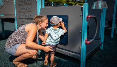 Child looking in mirror with teacher