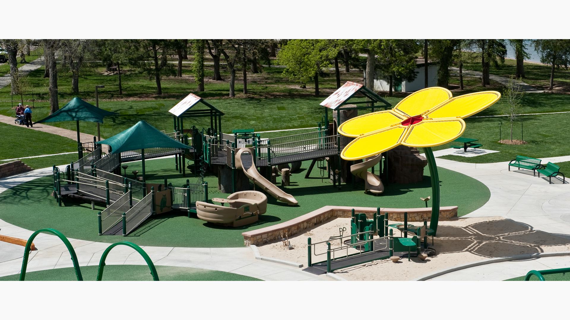 A custom yellow flower shade structure towers over Swing High Playground.