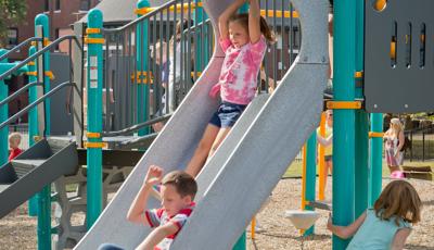 Boy and girl going down double slide