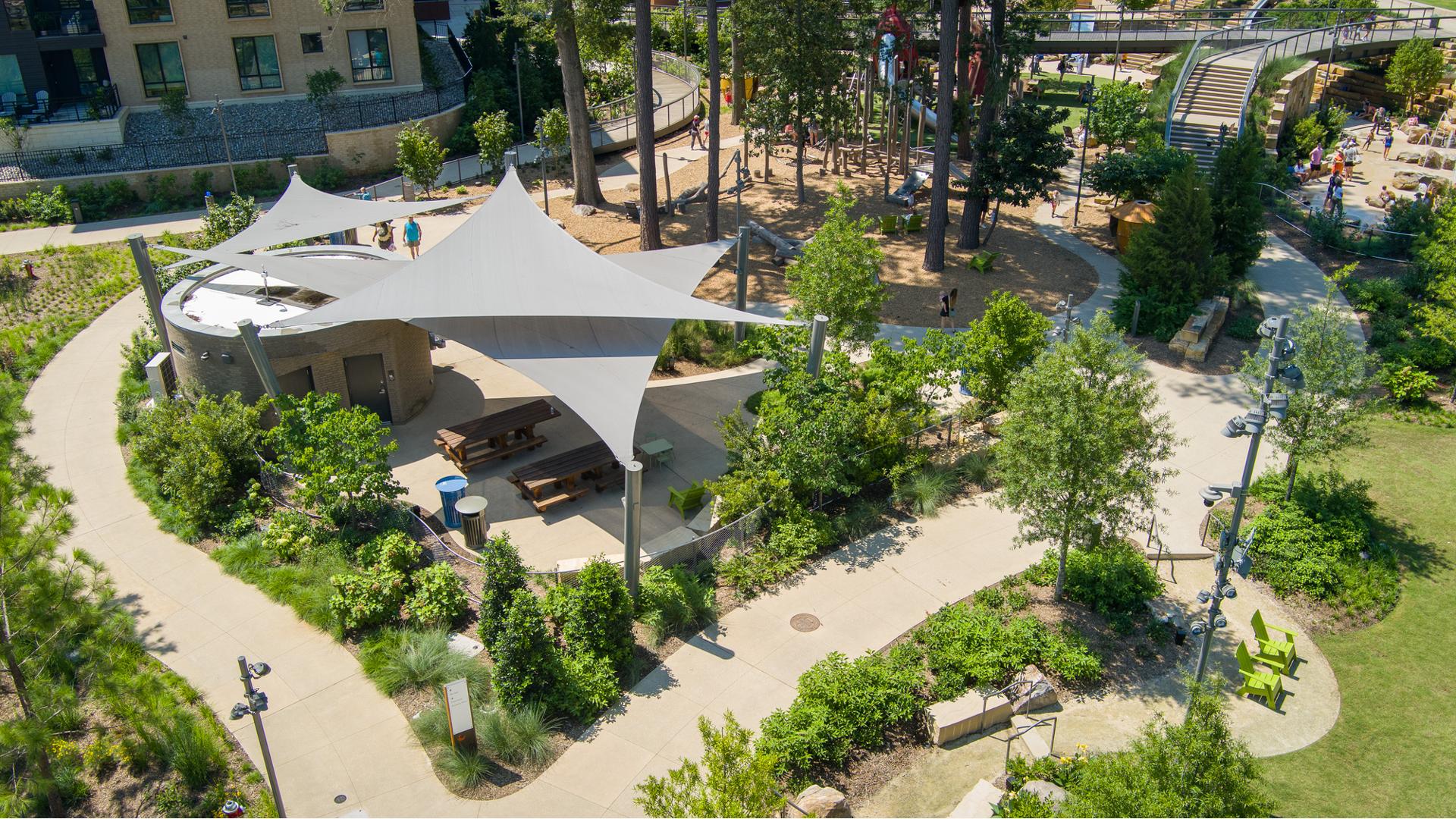 Elevated view of a park sitting area with three triangular shade systems.