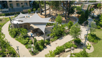 Elevated view of a park sitting area with three triangular shade systems.