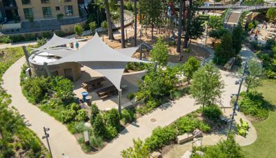 Elevated view of a park sitting area with three triangular shade systems.
