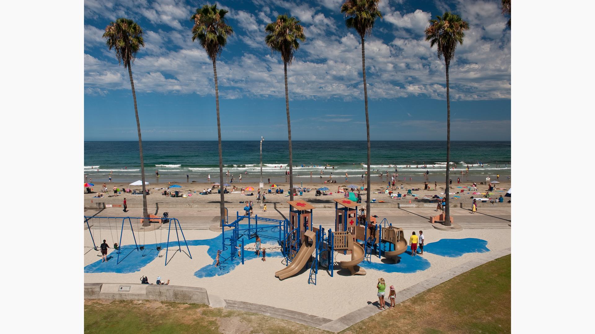 Kellogg Park in La Jolla, CA. A beach-themed PlayBooster® playstructure for ages 5 to 12. Playground features Custom play panels and signage against the background of the pacific ocean.