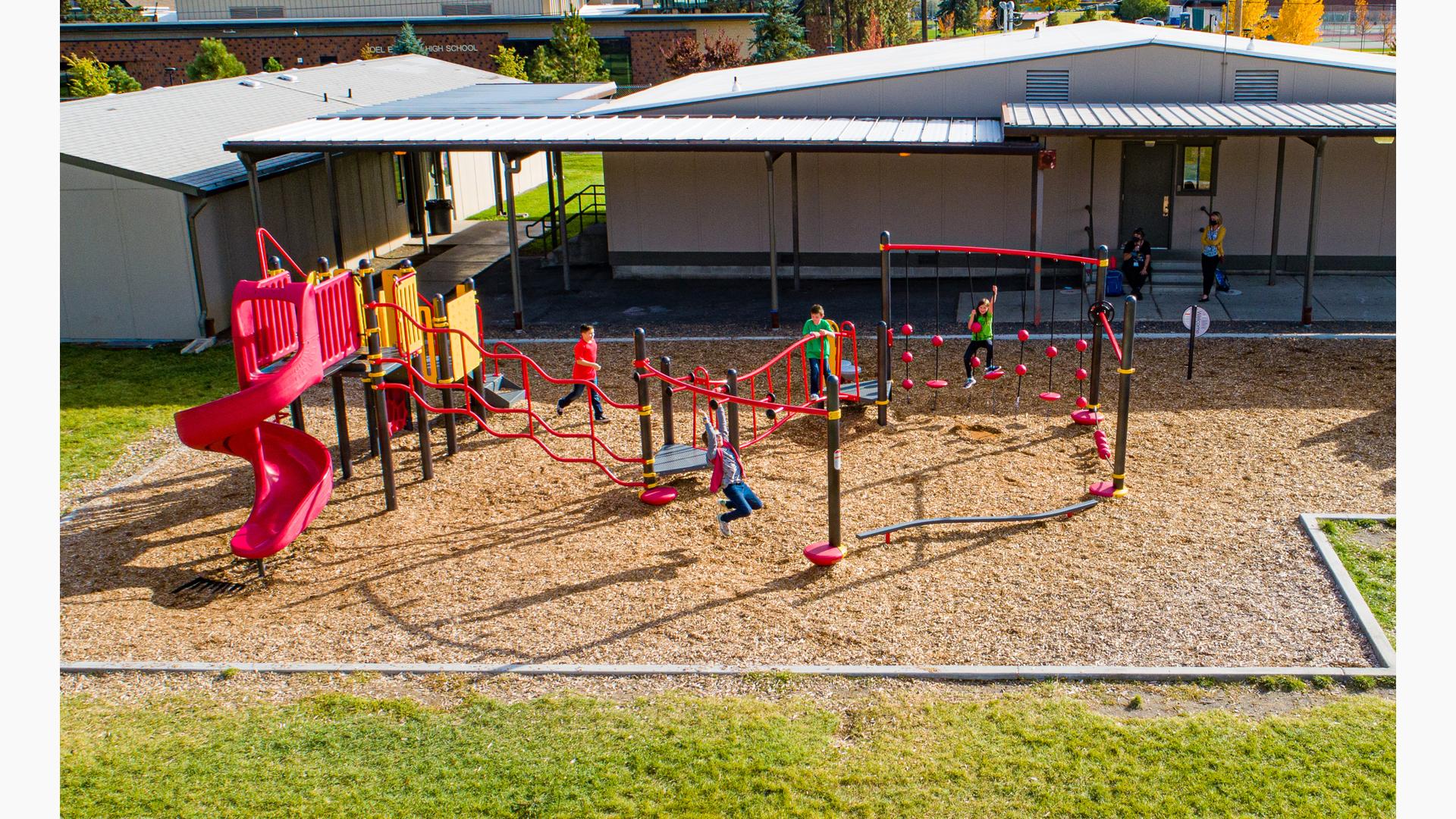 Fitness-focused playground at a school for children ages 5 to 12 with multiple climbing and bridging activities.