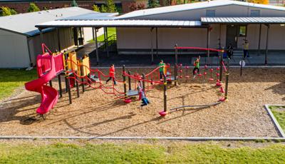 Fitness-focused playground at a school for children ages 5 to 12 with multiple climbing and bridging activities.