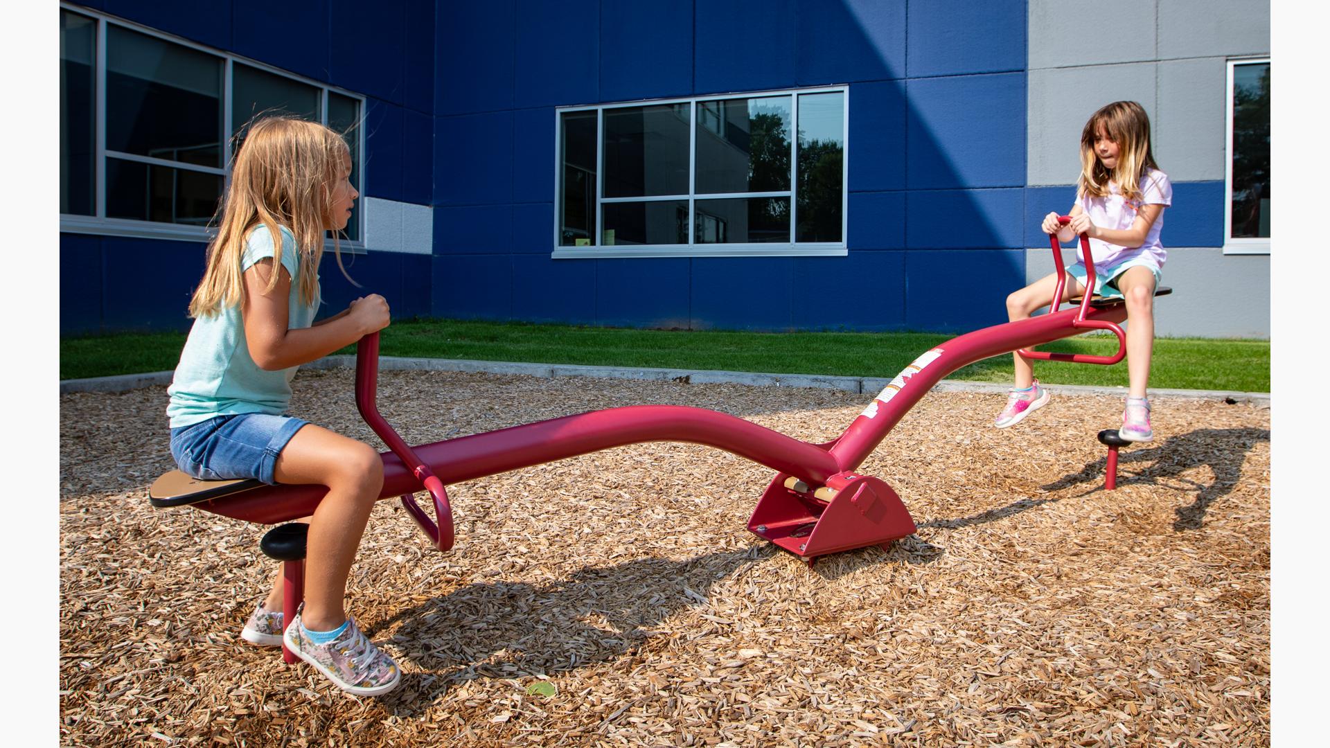 Girls riding see-saw