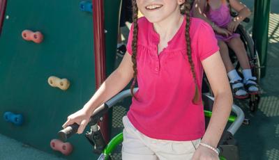 Girl smiles as she walks onto playground