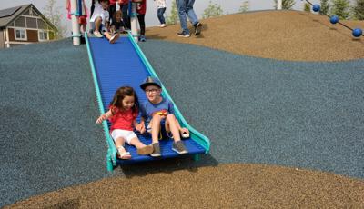 Boy and girl riding down slide