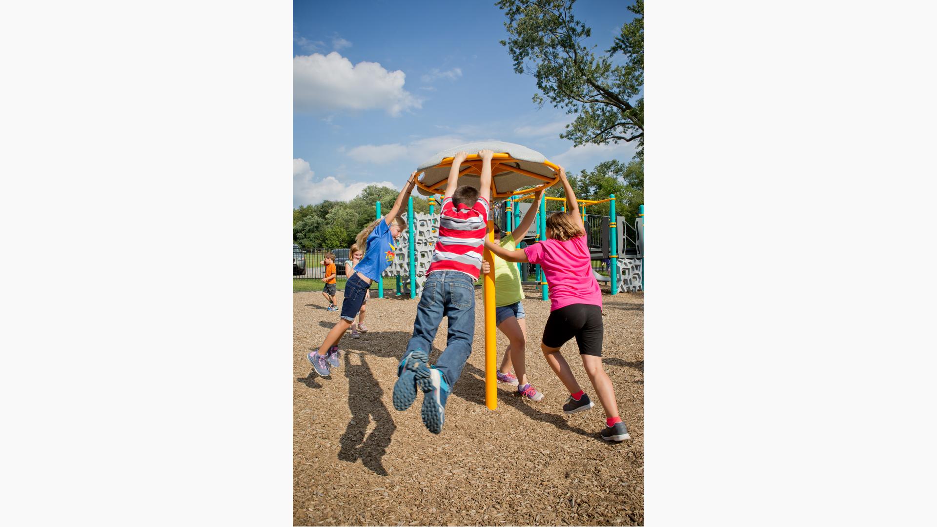 Kids swinging on a Flywheel® spinner