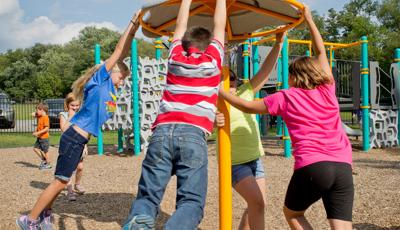 Kids swinging on a Flywheel® spinner