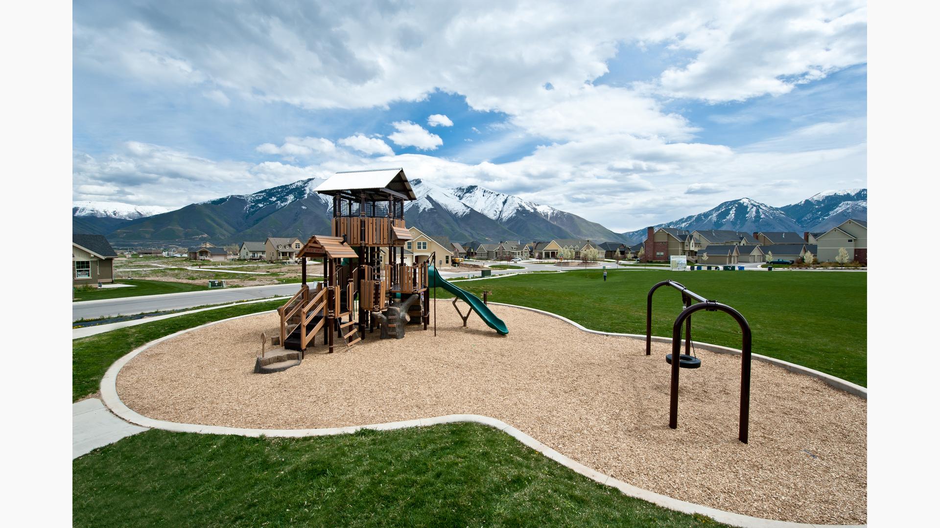 Nature-inspired playground tower with snow-capped mountains in the background.