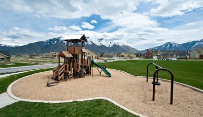 Nature-inspired playground tower with snow-capped mountains in the background.
