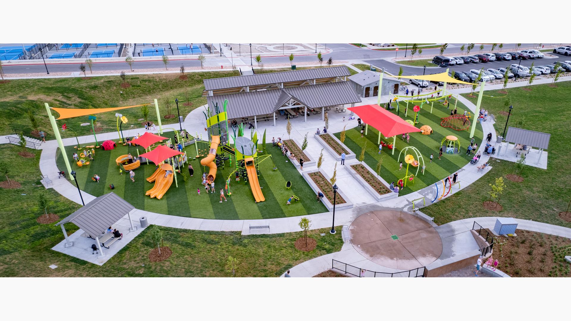 Elevated view of a large half moon shaped play area filled with play structures, swings, and climbers.