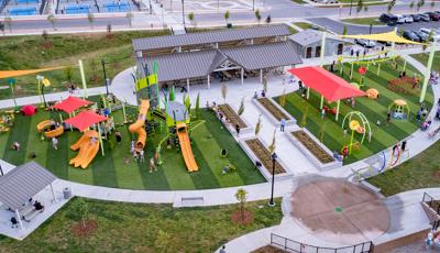 Elevated view of a large half moon shaped play area filled with play structures, swings, and climbers.