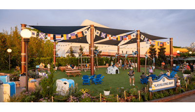 Families playing at a playground with shade sails over head.