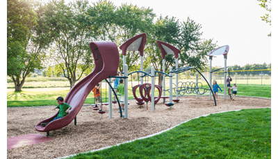 A group of children play together at a park playground.