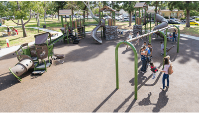 Parents play with their kids on the swings at Reservoir Park.