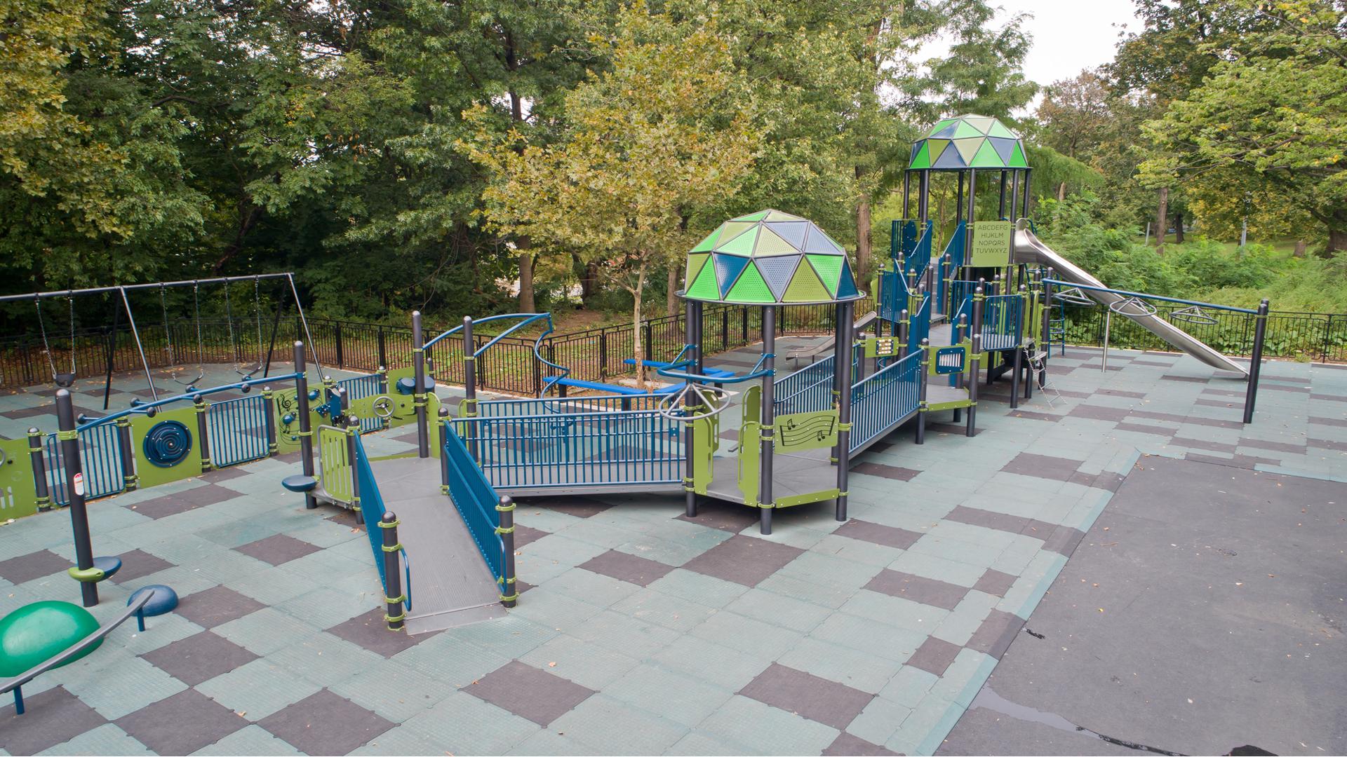 A play structure connected with accessible ramps and bridges allow for all abilities to reach and play at different play panels, climbing activities, and slides.