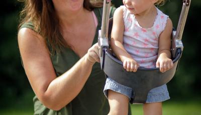 Woman pushes little girl on Full Bucket Seat w/Chains