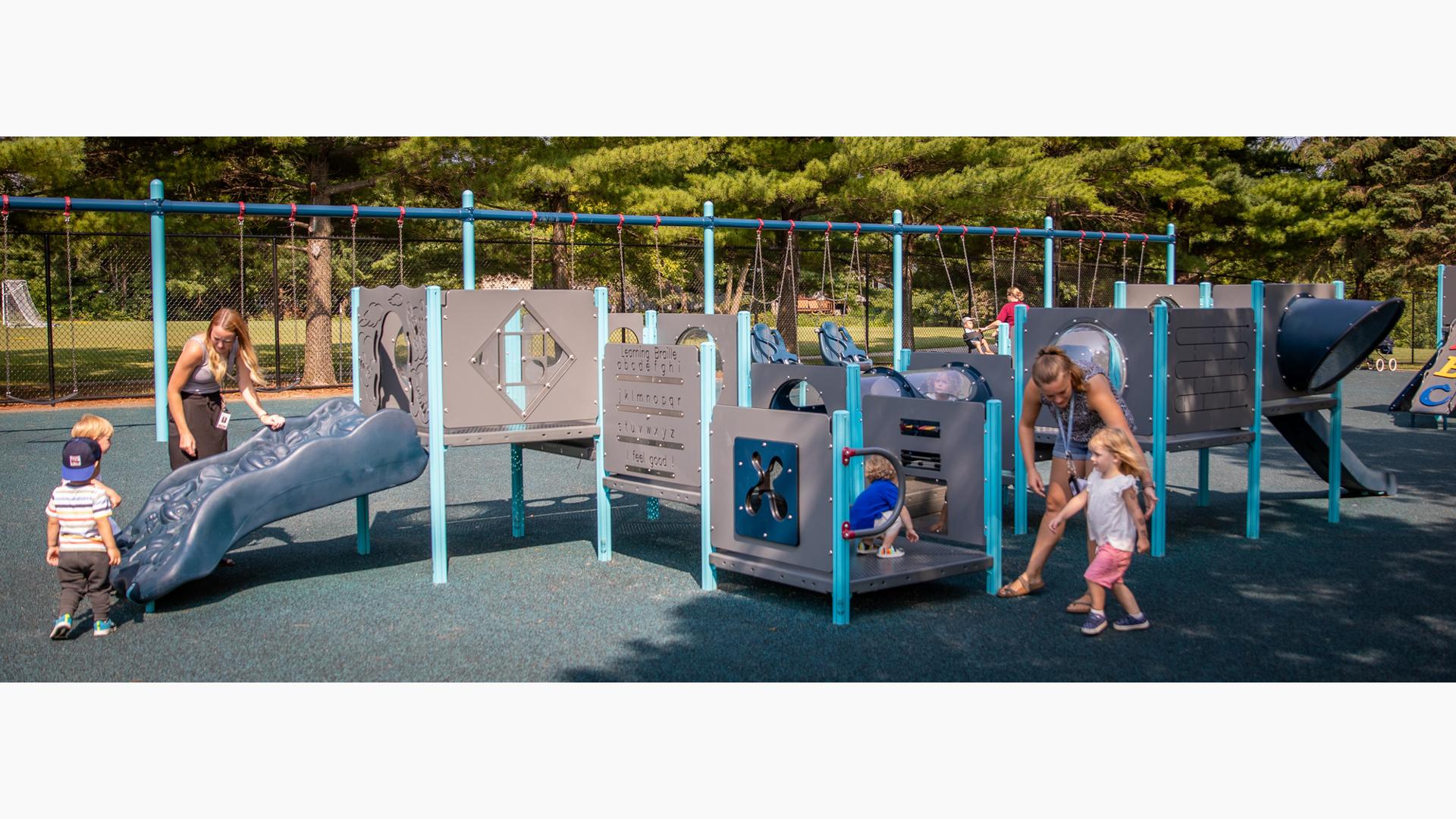 Teacher with kids playing on PlayShaper® play structure. For kids ages 6 to 23 months.