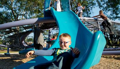 Boy having fun riding Quantis™ netplay concept slide