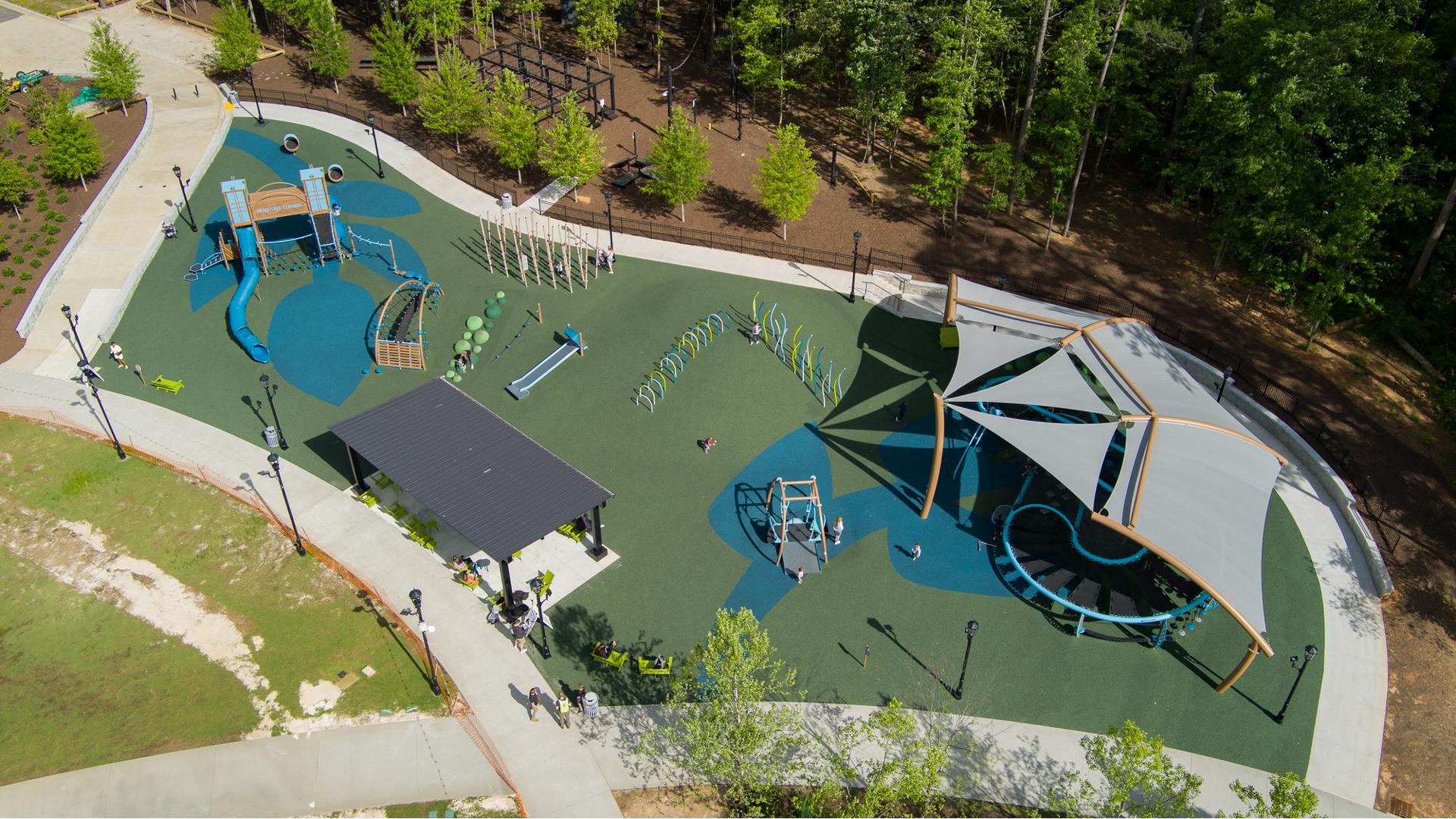 Bird's eye view of a large inclusive playground with a shade system over the unique figure eight shaped play structure.