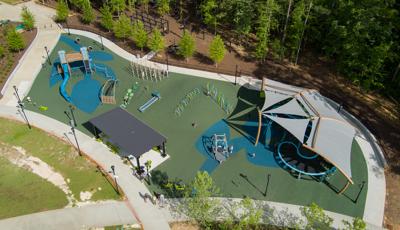 Bird's eye view of a large inclusive playground with a shade system over the unique figure eight shaped play structure.