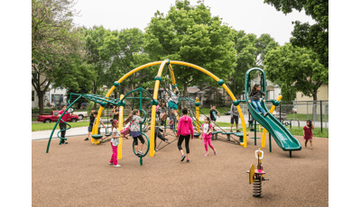 Children playing on a brightly-colored net structure over safety surfacing