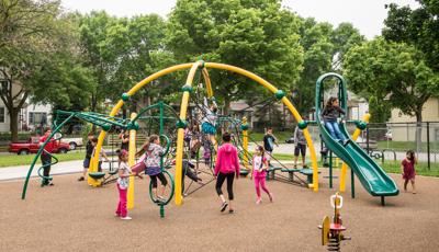 Children playing on a brightly-colored net structure over safety surfacing