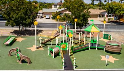 Playground at Ponderosa Elementary in Anaheim, CA. Green & yellow structure with star accents.  Inclusive play/Play Booster structure.