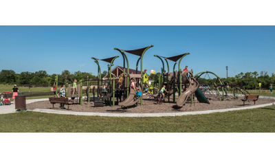 Children playing  in River's Bend park on a sunny day without a cloud in the sky on green grass.