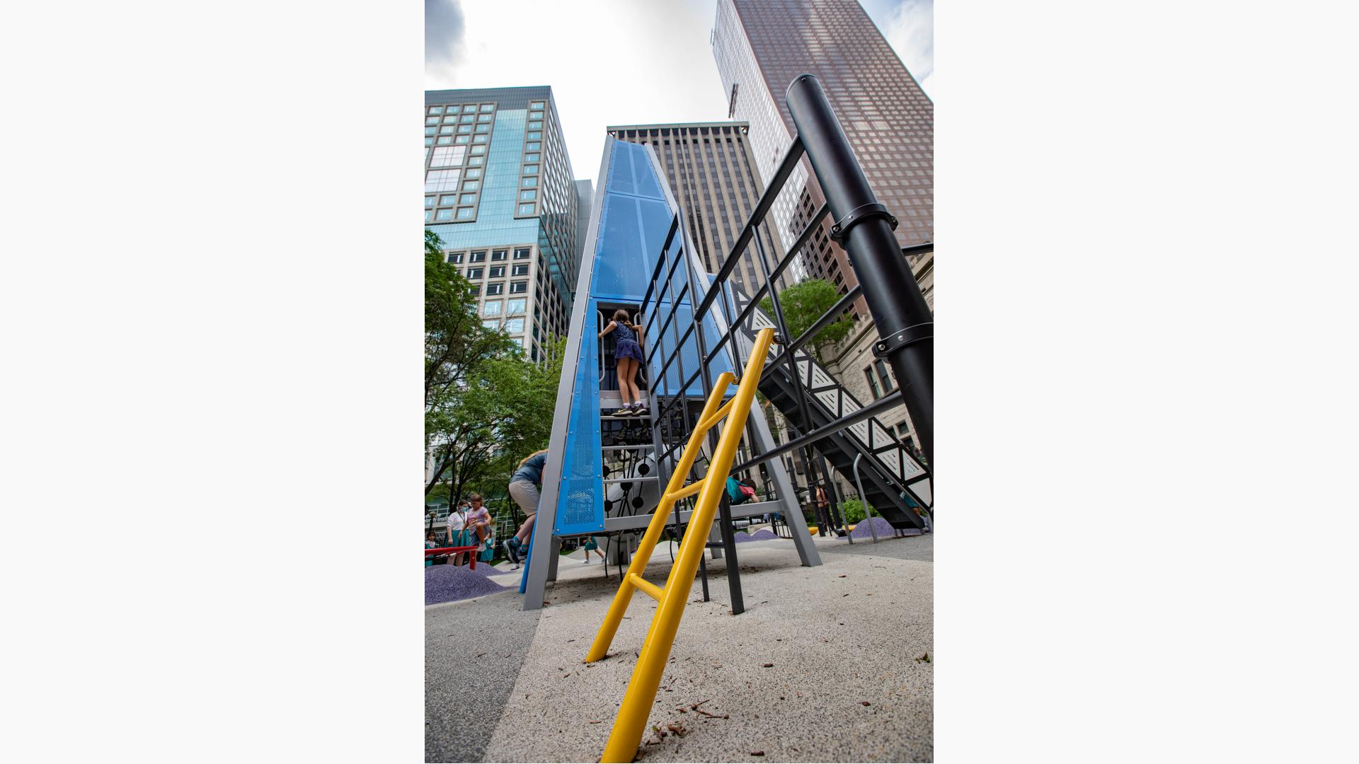 Girl standing on top step and looking inside custom play structure