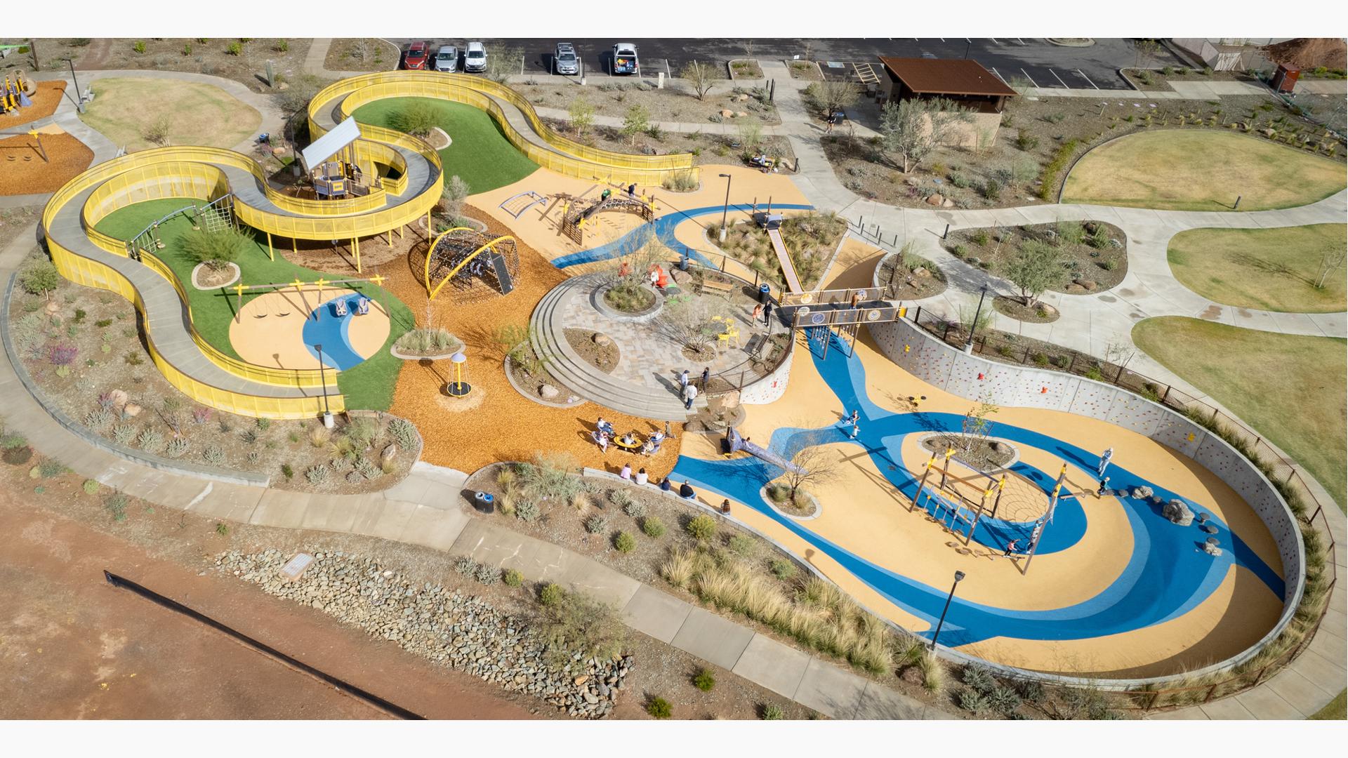 Elevated view of a large community play space with winding accessible ramps leading into play structures.