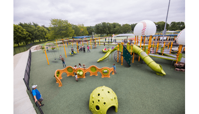 Kids playing on sensory play panels and swing sets.