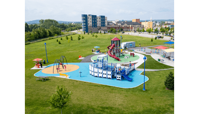 Elevated view of a park playground with a main play structure designed like a boat.