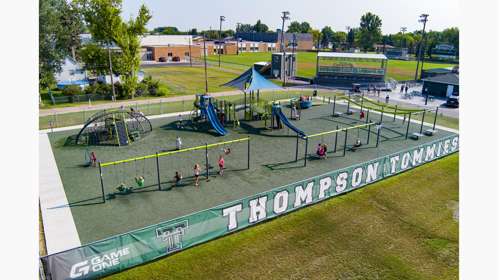 Elevated view of a fenced in playground with school children playing everywhere.