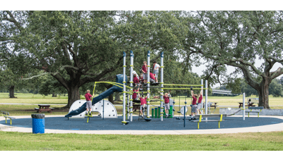 Boys in school uniforms playing on 7-post Netplex® PlayBooster play structure in a park.