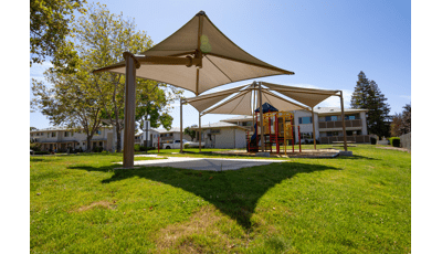 Parkview Apartments, Lincoln, CA. A PlaySense® play structure that includes playground slides, climbers, activity panels, overhead ladders, and SkyWays® shade canopies.