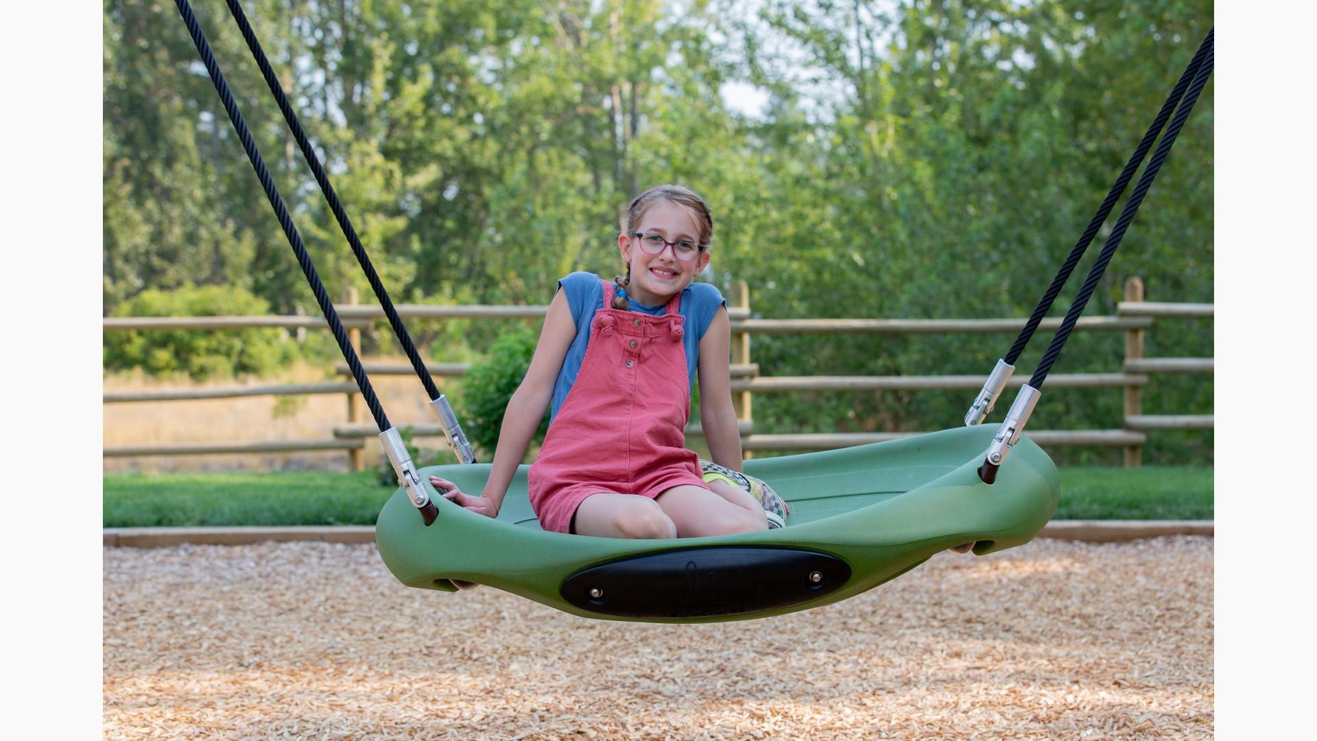 Girl sitting and smiling on Oodle® Swing