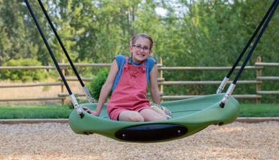Girl sitting and smiling on Oodle® Swing