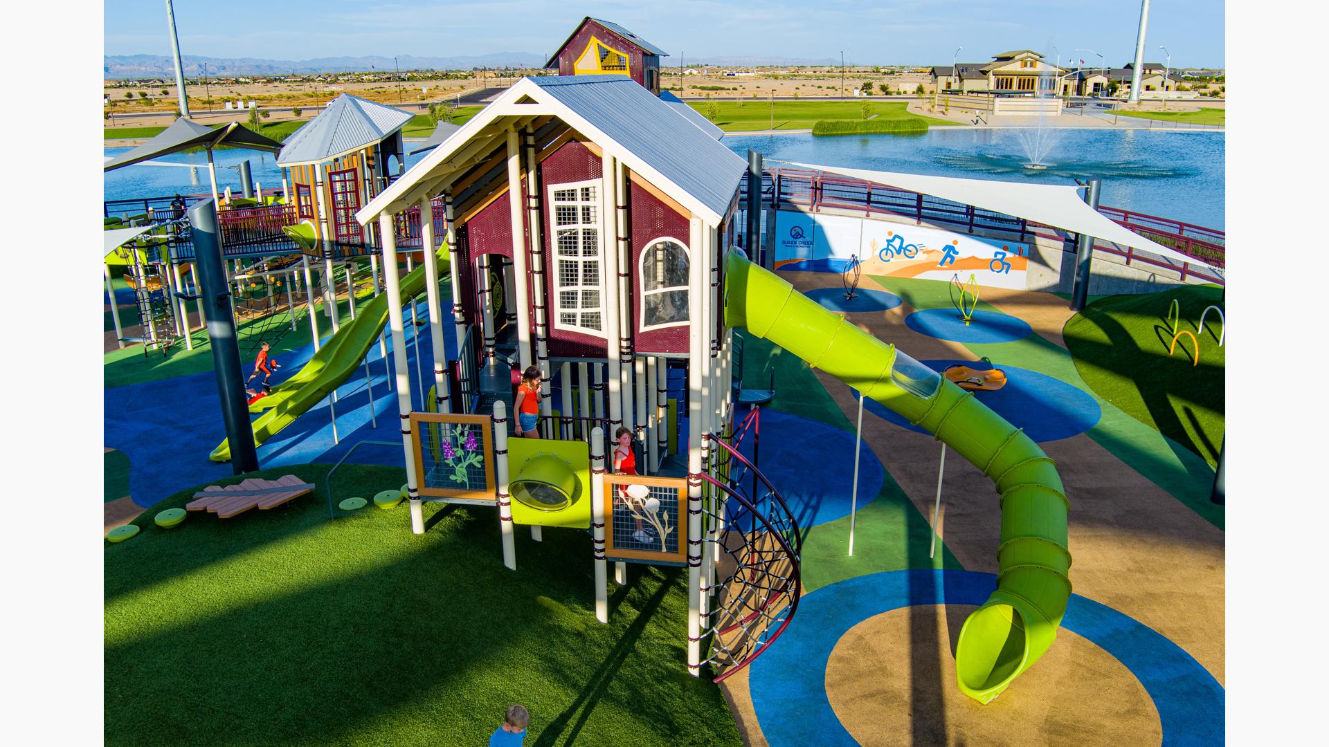 Elevated view of a tower house designed structure with a large green slide coming off the right hand side.