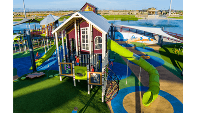 Elevated view of a tower house designed structure with a large green slide coming off the right hand side.