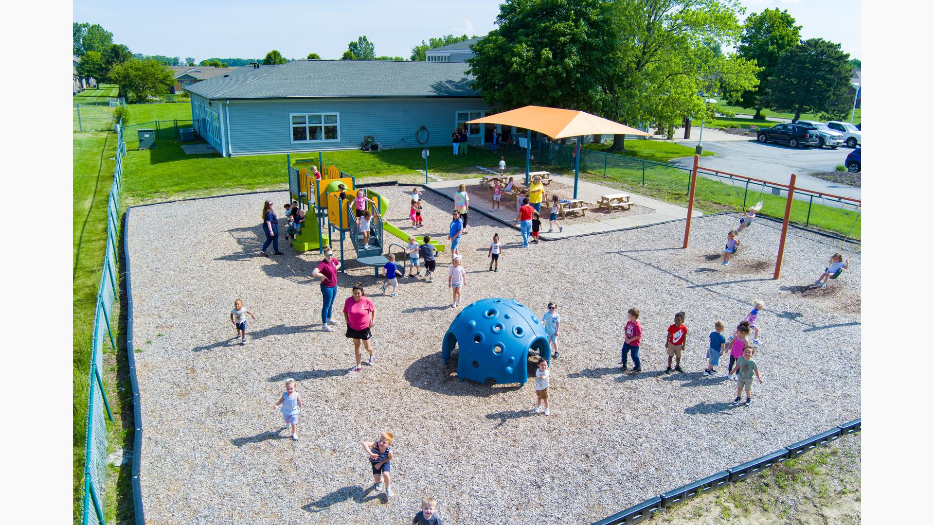 Elevated view of children playing on playground equipment at a learning center