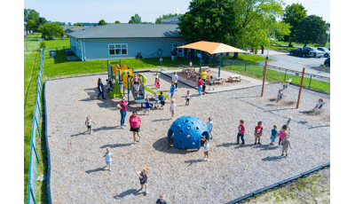 Elevated view of children playing on playground equipment at a learning center