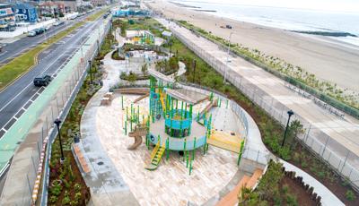 Elevated view of three separate play areas strung along an ocean beach and a city street. 