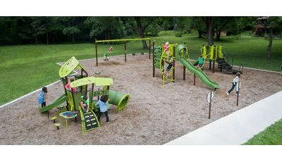 Kids playing on SmartPlay and PlayBooster structures. Two kids play on the swings.