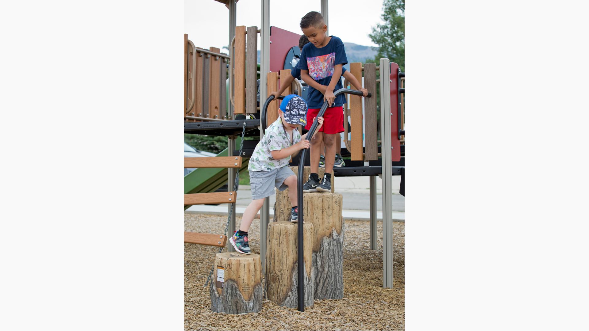 Two boys walking on log steppers
