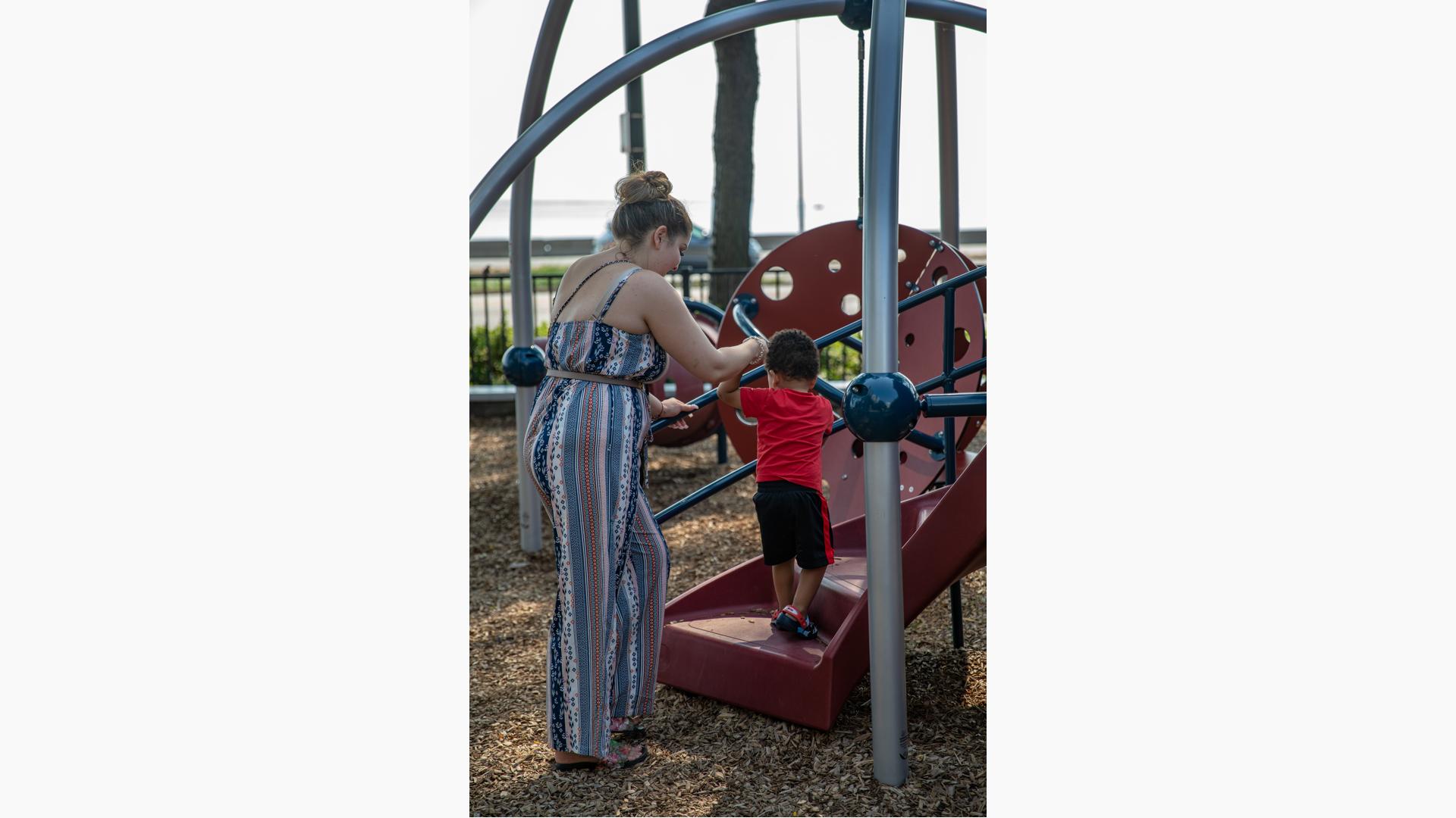 Mom holds son's hand to climb stairs